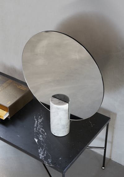 specchio di forma circolare con supporto dal design elegante