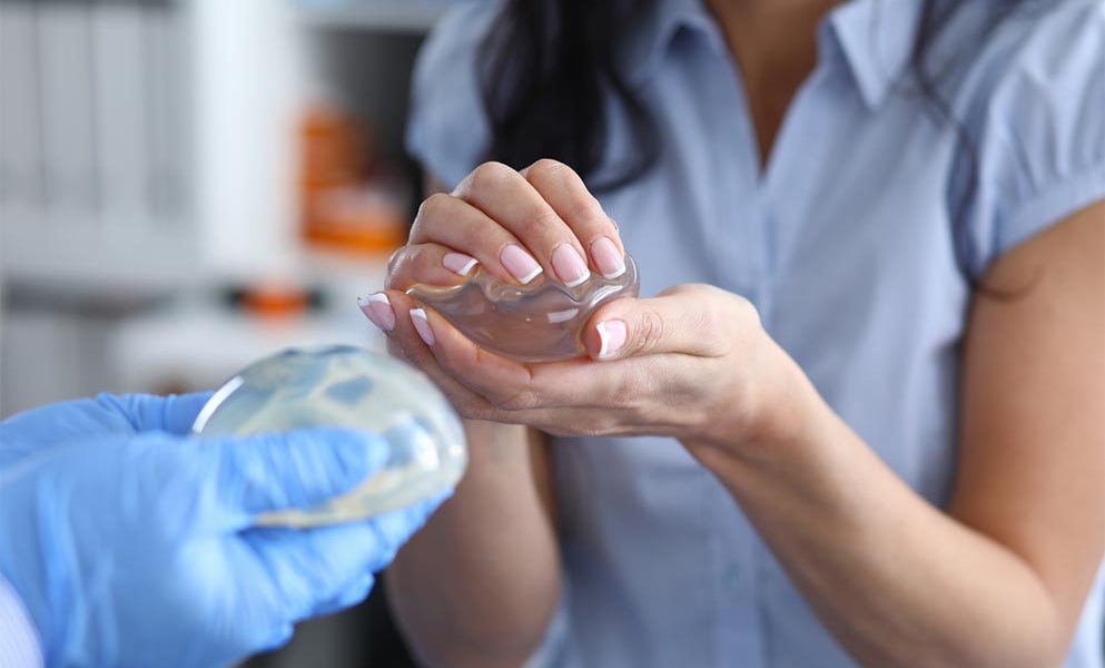 Doctor demonstrates silicone breast implants to woman
