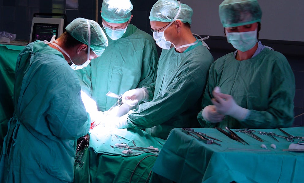 Surgeon's gathered around an operating table