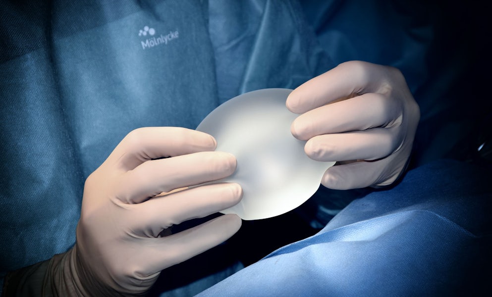 Surgeon holding a silicone breast implant