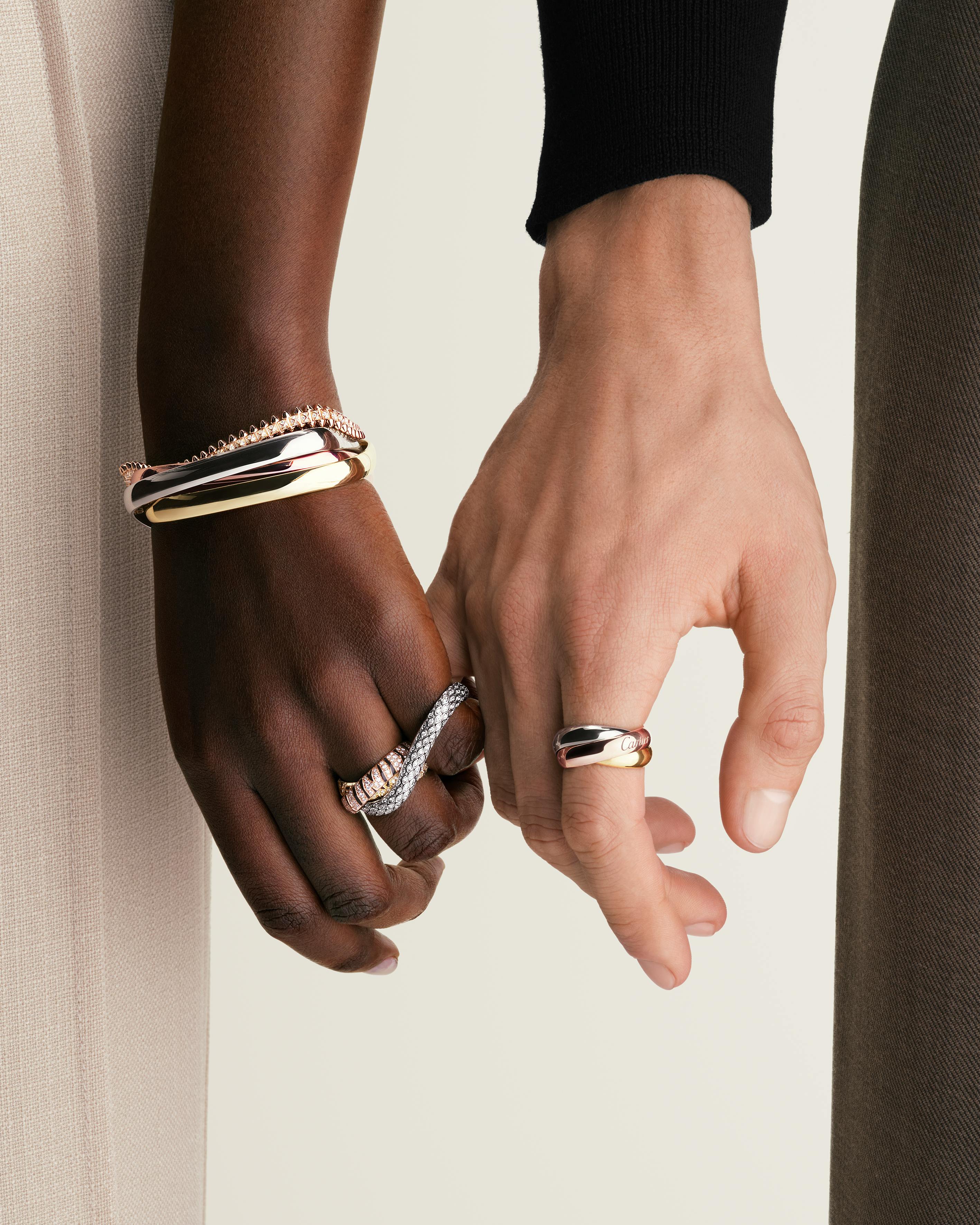 Cartier Love bracelet Trinity ring close-up on fabric background editorial moody natural light