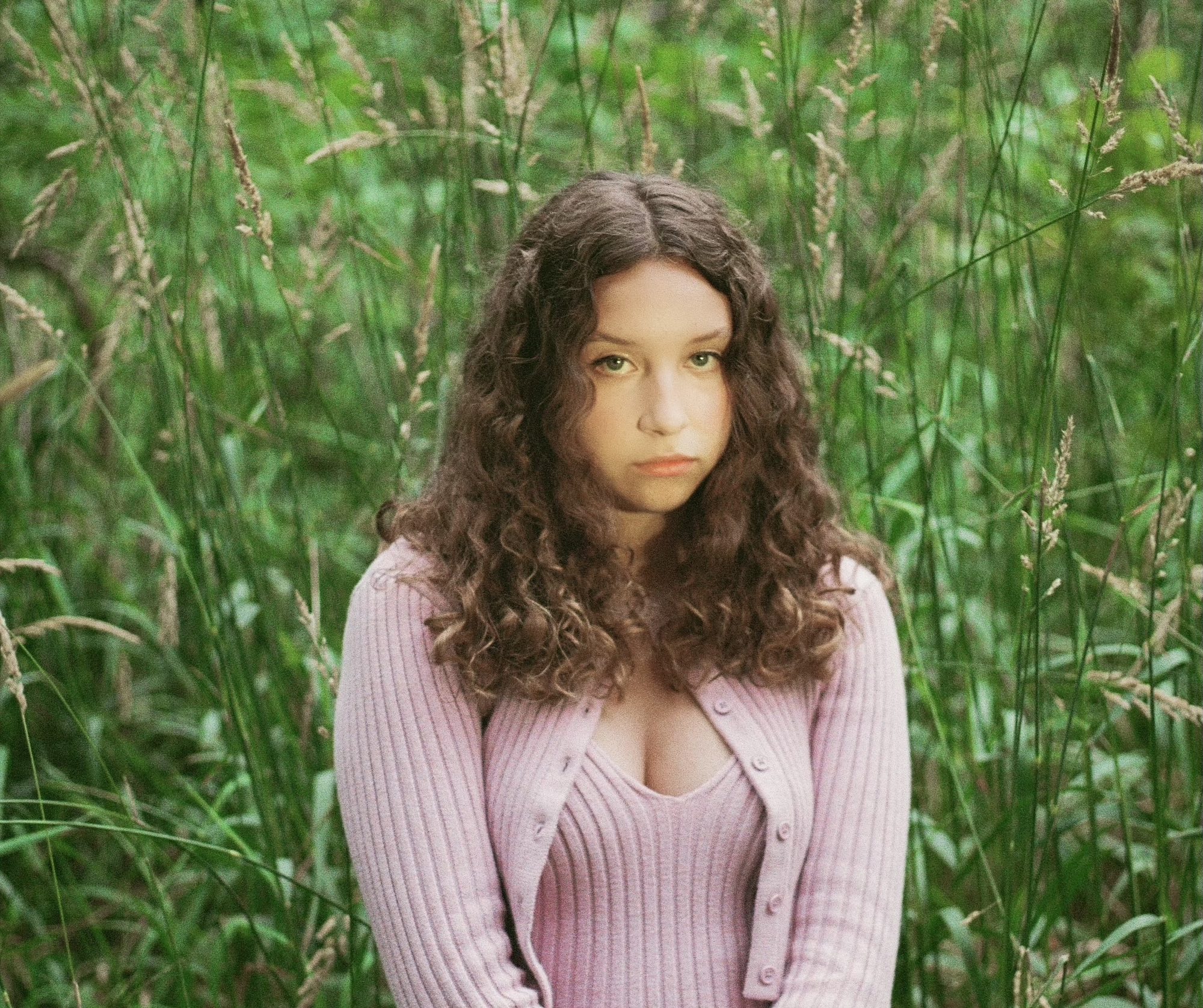 Lia Pappas-Kemps sat in a field of long grass