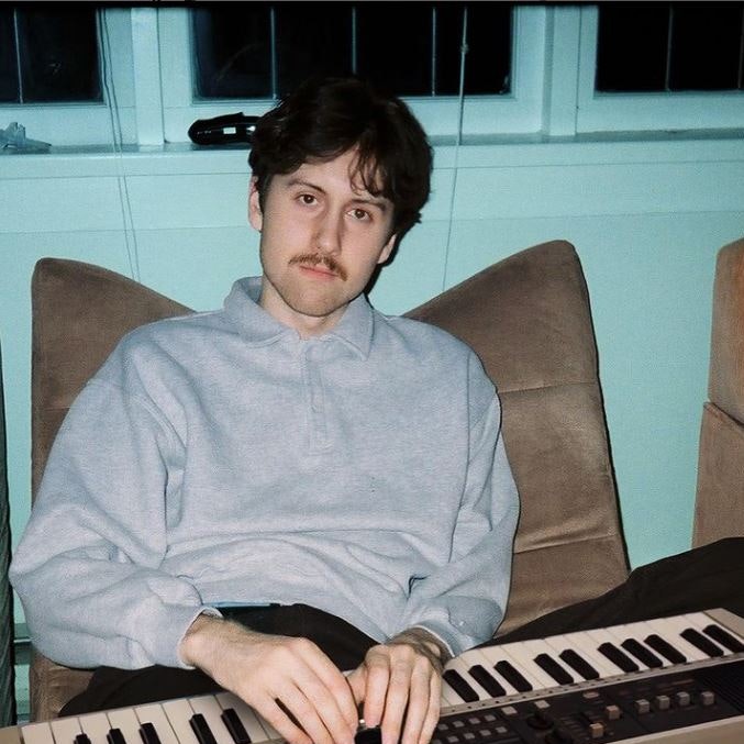 max boonch sat in a chair with a keyboard on his lap