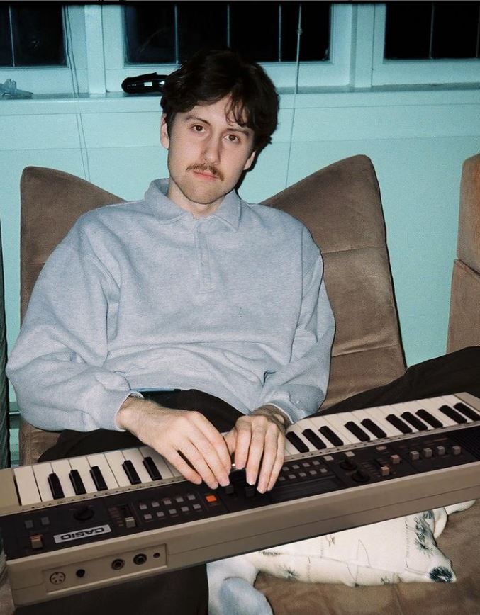 max boonch sat in a chair with a keyboard on his lap