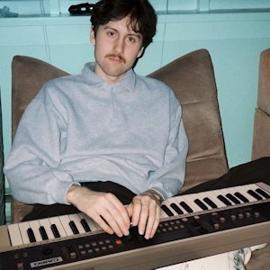 max boonch sat in a chair with a keyboard on his lap