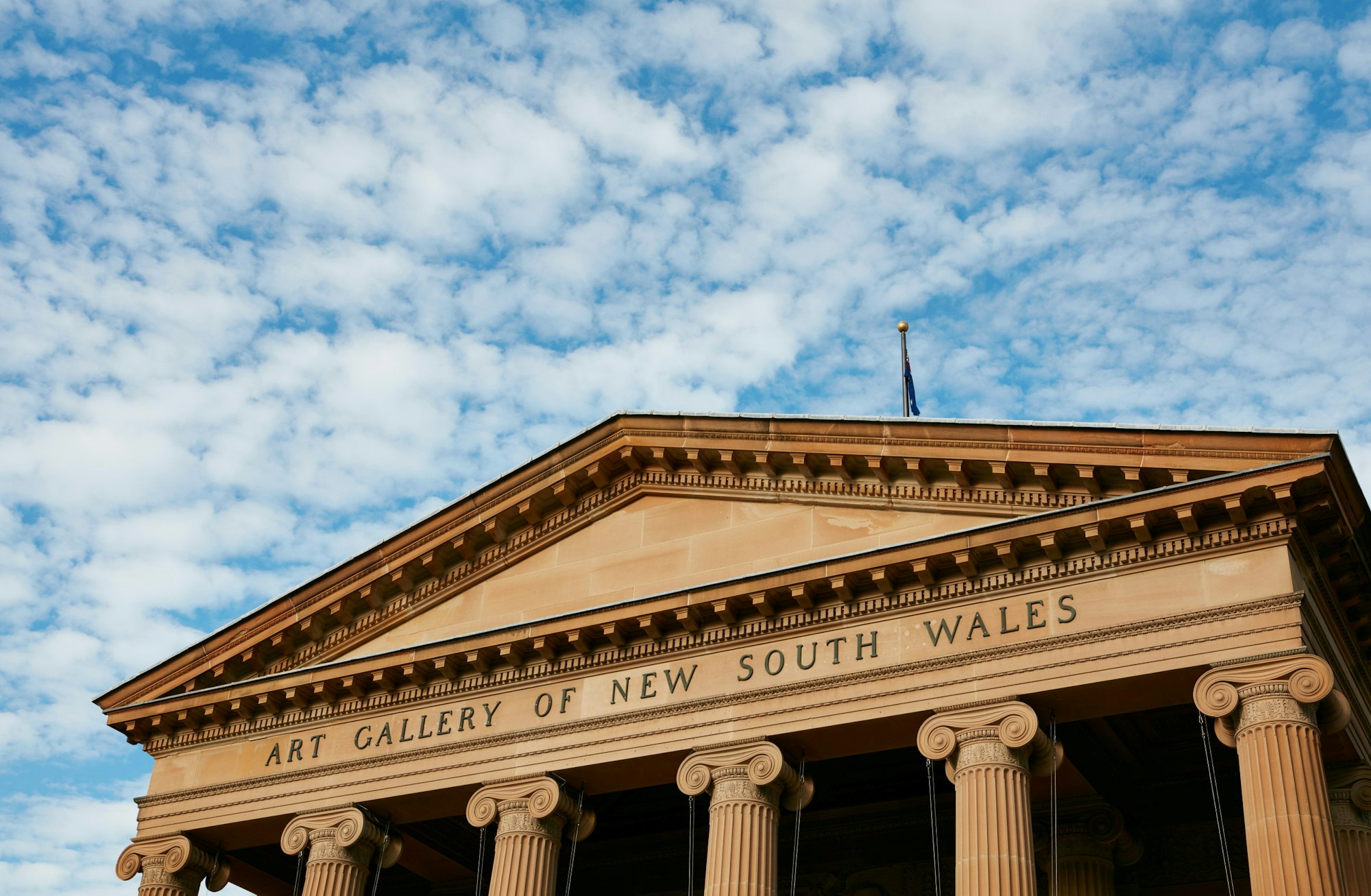 The front facade of the Art Gallery of NSW with a blue sky 