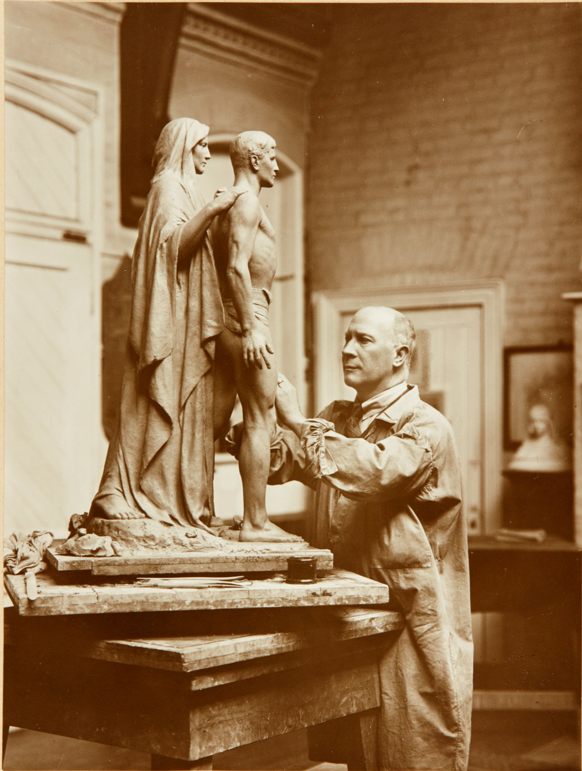 Bertram Mackennal working on the plaster cast of the figures for his Blackburn War Memorial