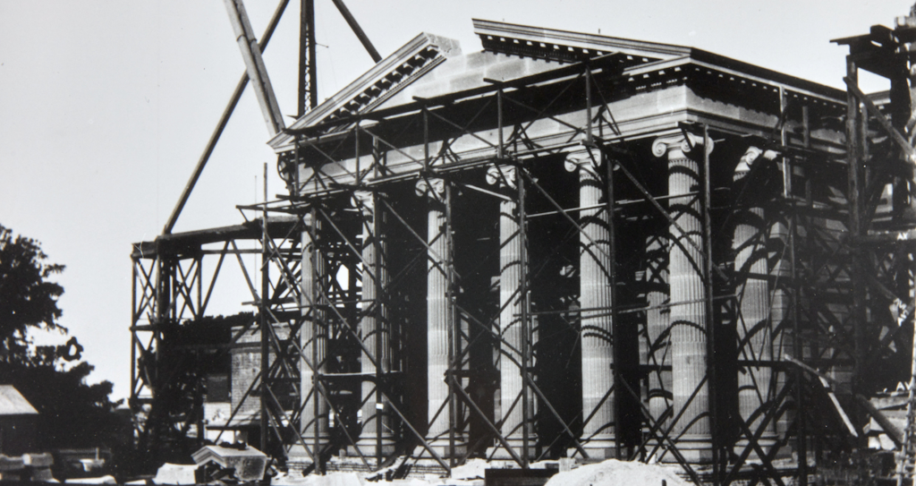 Historical exterior view of the final stone about to be placed in the pediment above the entrance portico of the Gallery from the Art Gallery of New South Wales Institutional Archive 24 March 1902