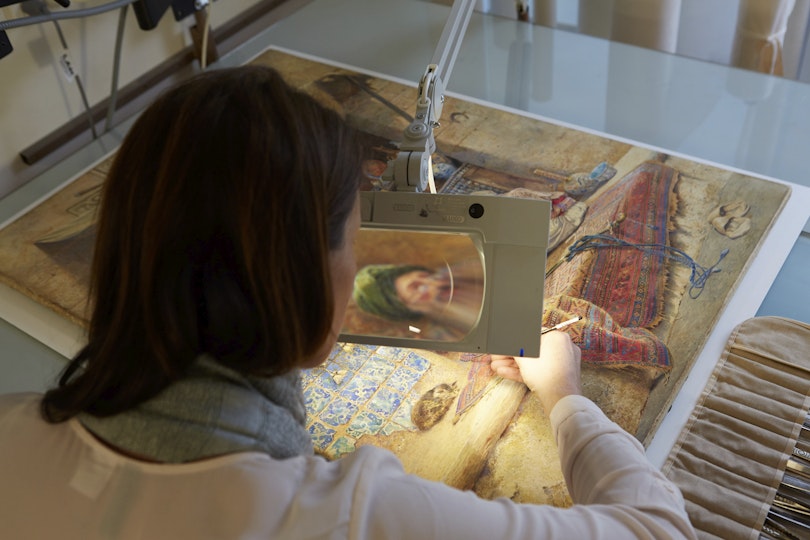 Paper conservator Analiese Treacy works on a c. 1886 watercolour, Bazaar gossip, by Charles Robertson.