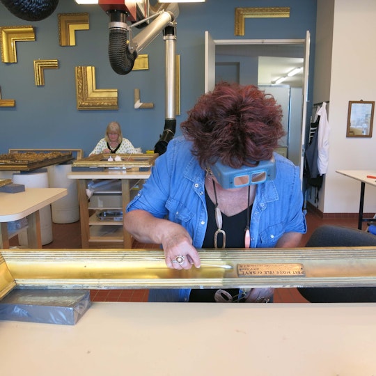 Margaret Sawicki, Head of Frames Conservation, and senior frames conservator Basia Dabrowa work on ornate gilded frames for the Victorian Watercolours exhibition. 