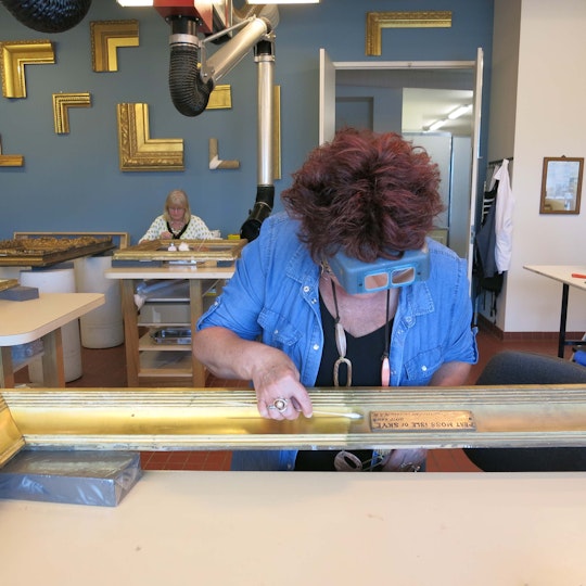 Margaret Sawicki, Head of Frames Conservation, and senior frames conservator Basia Dabrowa work on ornate gilded frames for the Victorian Watercolours exhibition.