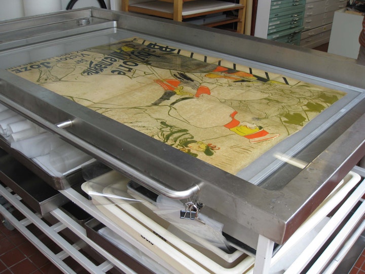 A large-scale poster by Henri Toulouse-Lautrec receives a wash in the paper conservation lab. Project supported by the Conservation Benefactors.