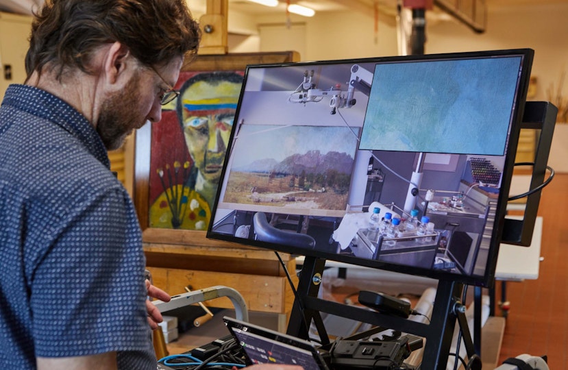 Conservation during the COVID-19 Lockdown. Audio Visual Operator Charles Lawler records the cleaning of Arthur Streeton's 1894 painting The Gloucester Buckets. Supported by Peter and Judy Howarth and the AGNSW Conservation Benefactors. Sidney Nolan’s Self Portrait, 1943, is seen at left.