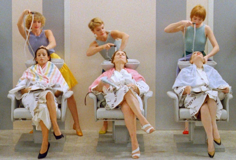 Three people having their hair washed by three hairdressers.