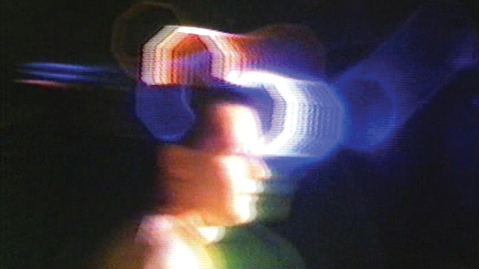 Video still of a person in profile, with lights refracting around their head.