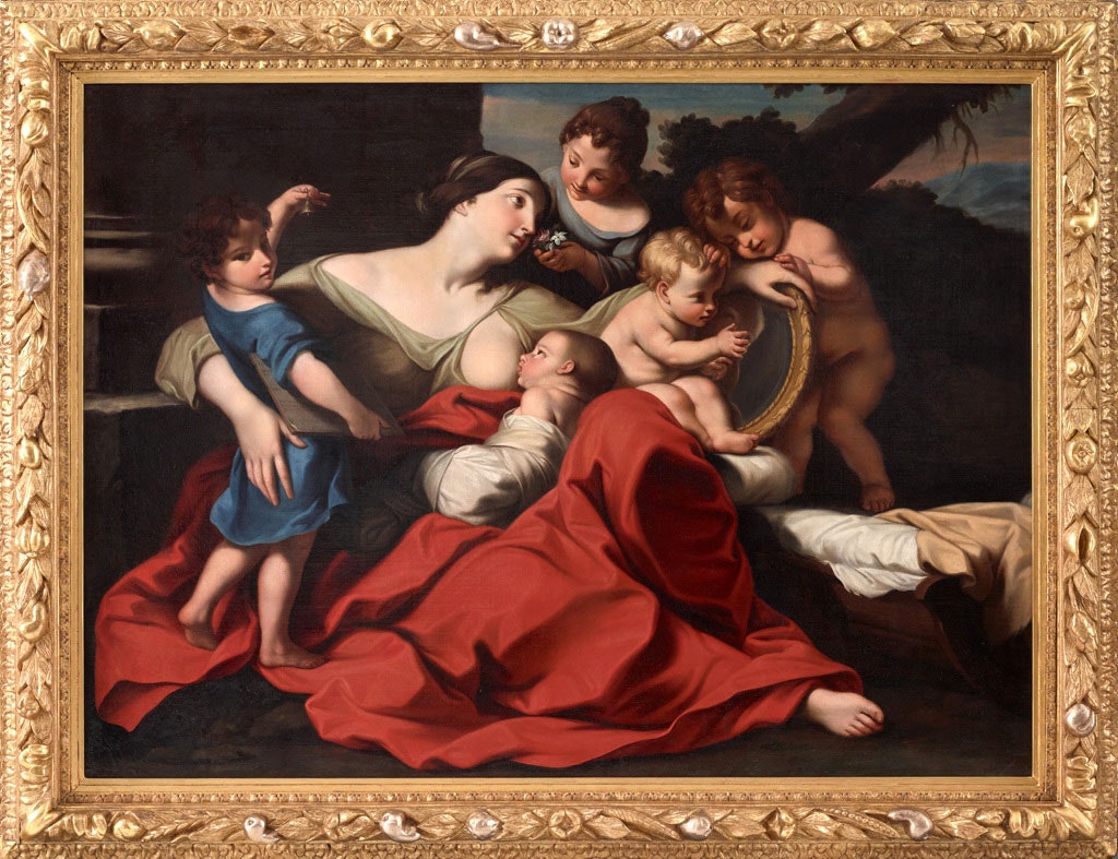 A painting of a seated woman surrounded by five children, the youngest of whom suckles at her breast. The painting is housed in an ornate gold frame.