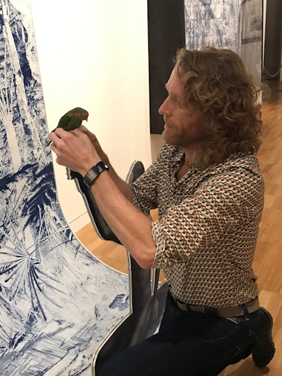 Danie Mellor secures the lorikeet to the figure's finger