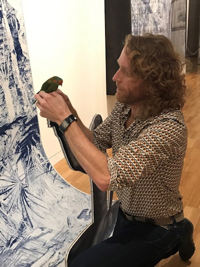 Danie Mellor secures the lorikeet to the figure's finger