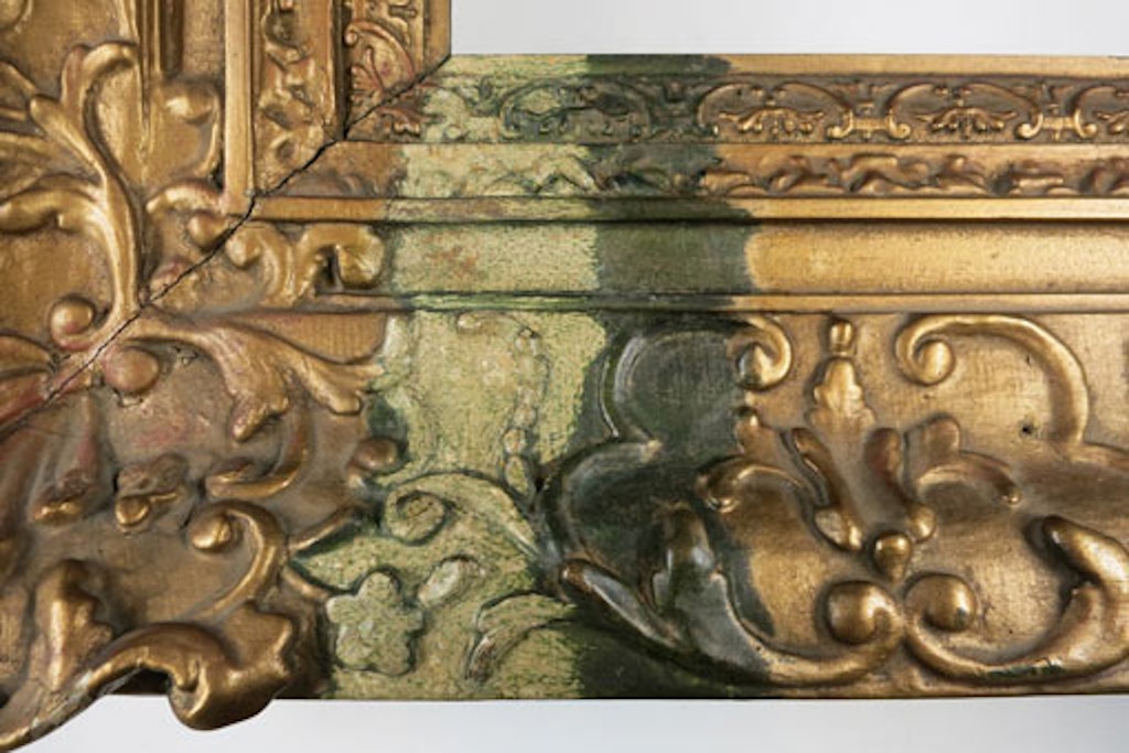 A green corrosion layer revealed under the brass-based paint layer on the frame