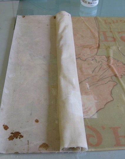 h3. Removing the backing
While damp, the old linen backing - often mouldy and stained - was removed gently and slowly to ensure no areas of the poster were disturbed. The linen has been kept for future reference.