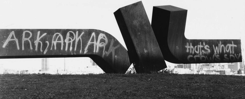 In 1983, the sculpture was graffitied with two types of spraypaint. Attempts to remove the paint from the fragile rusted surface created a ghosting effect.  Meadmore was consulted. ‘Paint it black,’ he said.
                                                
                                                The sculpture was taken away. The metal plates, which were trapping more water, were removed and the rust layer was blasted off, before the surface was first hot metal sprayed to give it a zinc coating then spraypainted black.