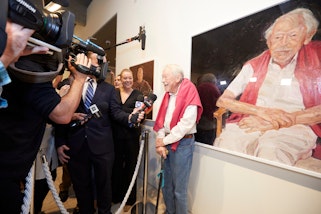 Guy Warren pictured in front of his Archibald Prize 2021 winning portrait by artist Peter Wegner Portrait of Guy Warren at 100. Photo: © AGNSW