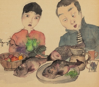 A woman and a man looking down at food on a table, including fish, a bowl of fruit, a jug and two mugs, as well as a thin branch with large flowers.