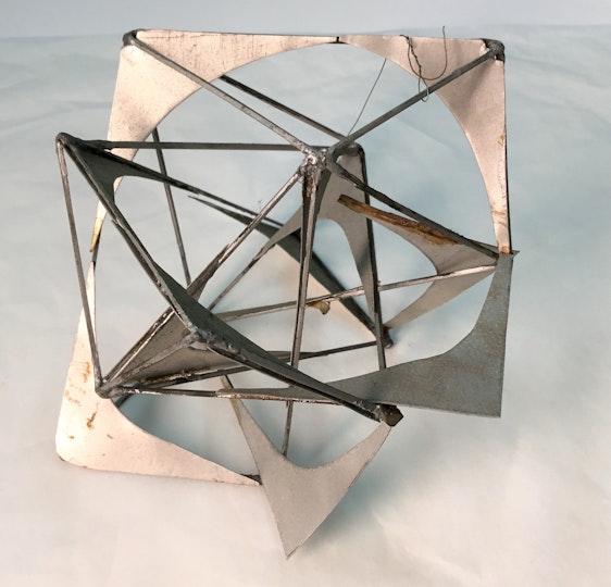A silver-coloured sculpture of interconnected open geometric shapes
