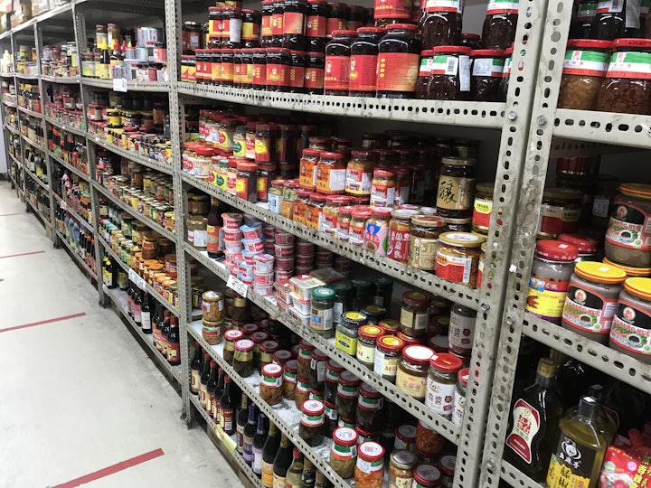 Shelves in an Asian grocery stocked with jars, cans and packages.