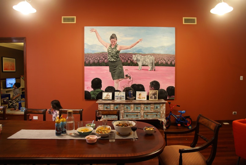 In a dining room, a table is set for dinner, with various bowls of food.