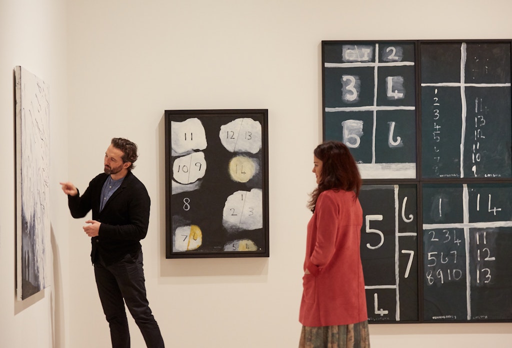 Justin Paton and Emma Burn with Tala Madani's [w[Cave interior (Ancestors)]] 2019 and Colin McCahon’s [w[Clouds 5]] 1975 and [w[Teaching aids 2 (July)]] 1975 © Estate of Colin McCahon, Courtesy of the Colin McCahon Research and Publication Trust 