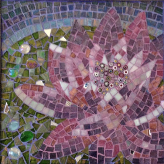Mosaic of a water-lily in shades of purple and pink, surrounded by green leaves and blue water.