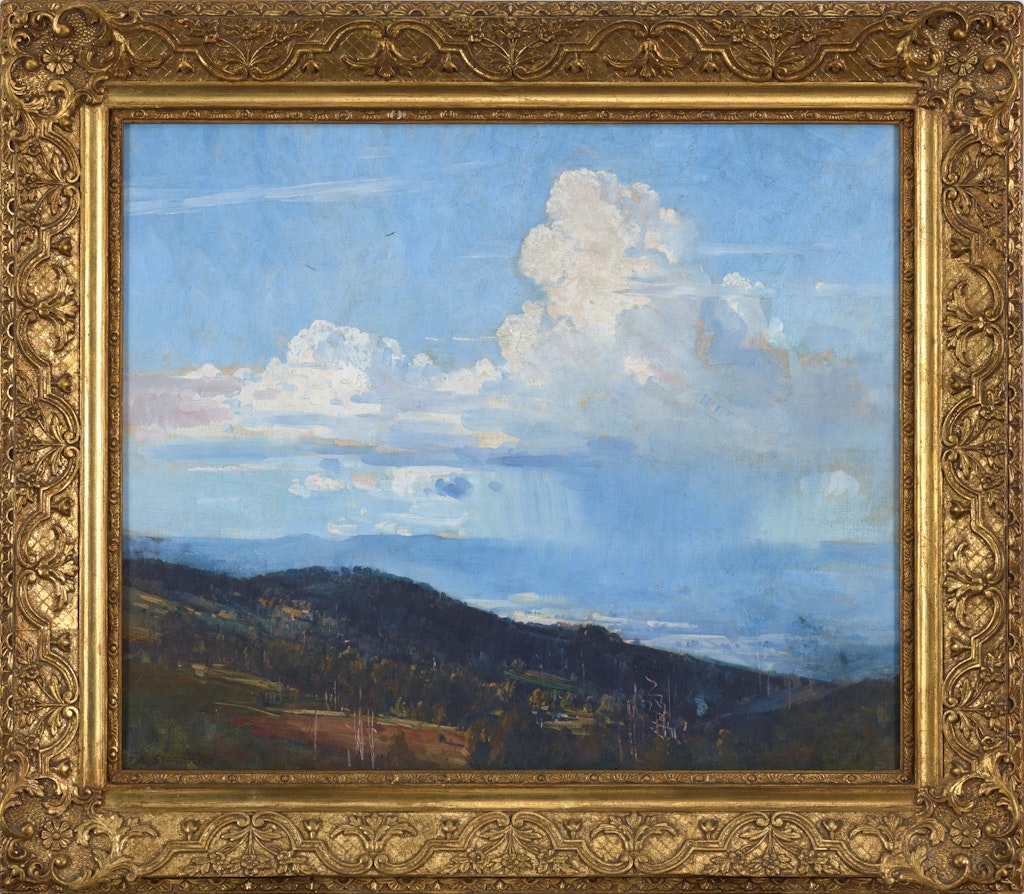 Gold-framed landscape painting featuring hills in the foreground and distant background and large clouds in a blue sky.