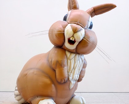 A sculpture of a large brown and white rabbit, standing.