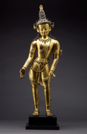 Gold-coloured statue of a standing Bodhisattva.