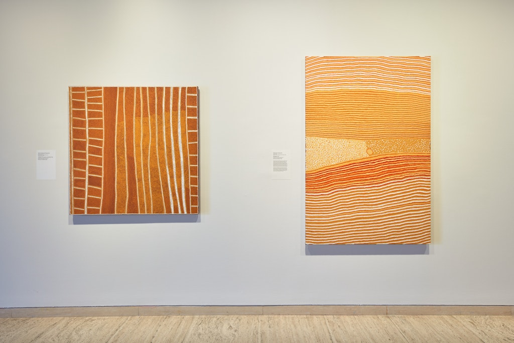 Installation view, featuring works by Patrick Olodoodi Tjungurrayi and Helicopter Tjungurrayi, from the exhibition The Purple House, Art Gallery of New South Wales, 2021. Photo © AGNSW