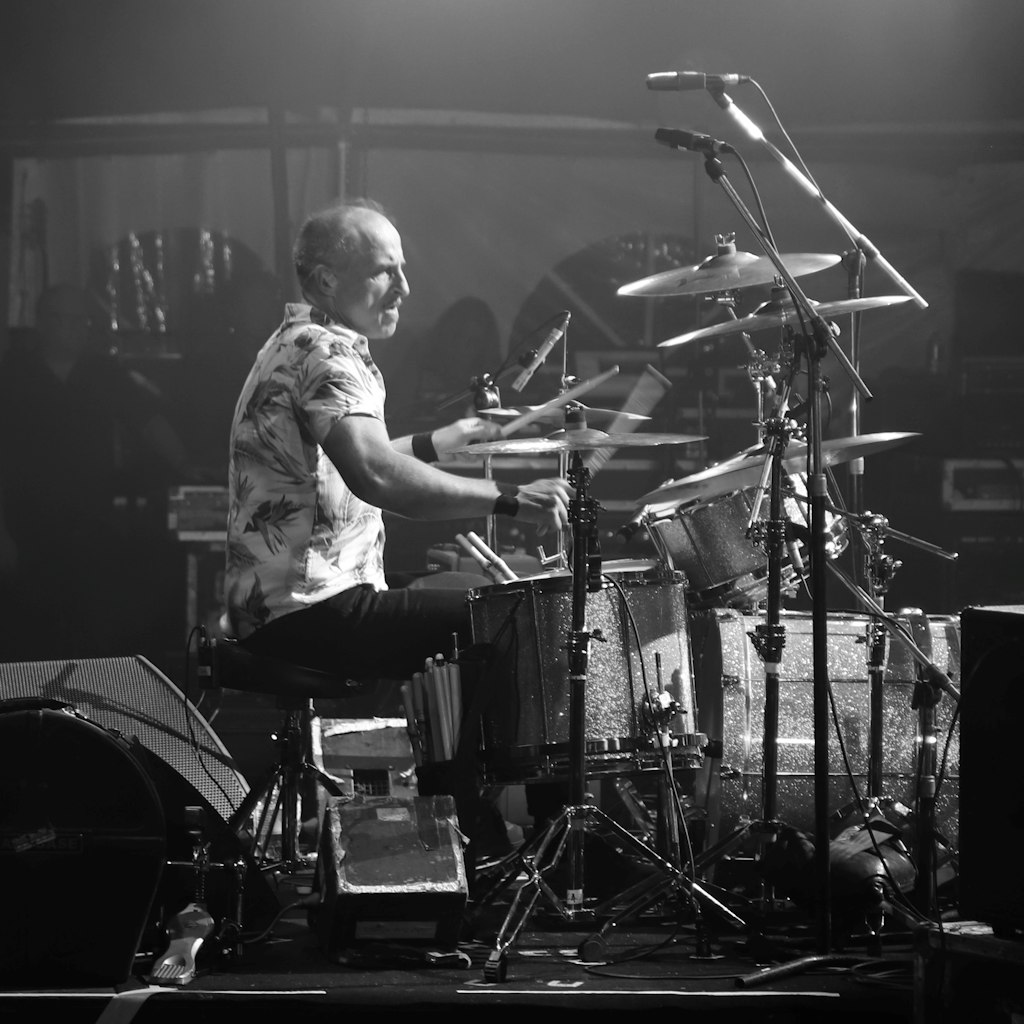 A black-and-white photo of a person playing drums.