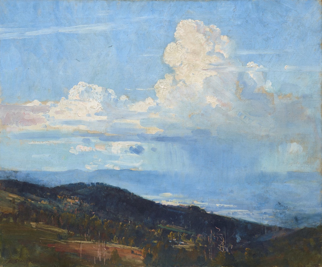 A blue sky with a large cloud from which rain falls on distant hills and pastures. There are green , sloping hills with trees in the foreground.