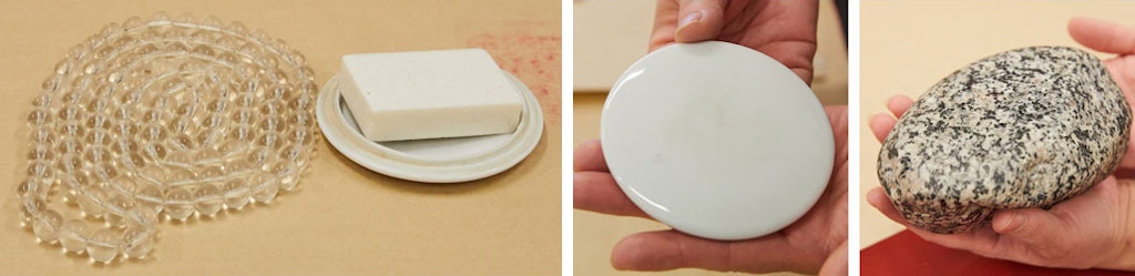 Clear beads lie on a surface next to a white dish holding a small slab of white material. In the next photo, two hands hold a flat, shiny white disk. In the third photo two hands hold a smooth, speckled, oval rock