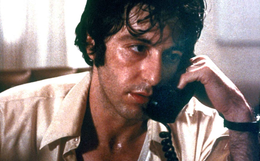 A person with light brown skin and a sweaty face holds a telephone to their ear.