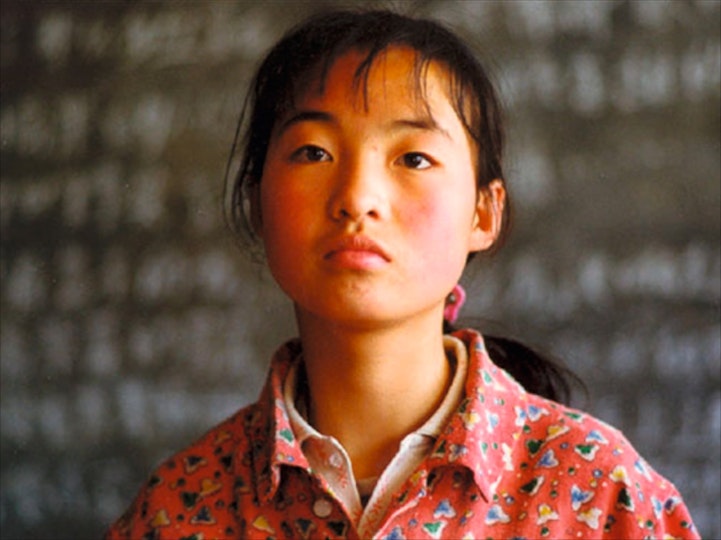 A child with black hair looks up.