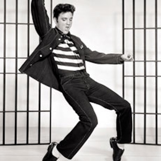 A man in s striped top dances on the tip of his toes.