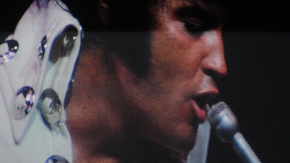 A close-up of a man singing into a microphone.