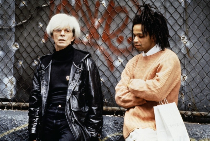 A person with light skin and bleached hair stands next to a person with light brown skin and black hair.