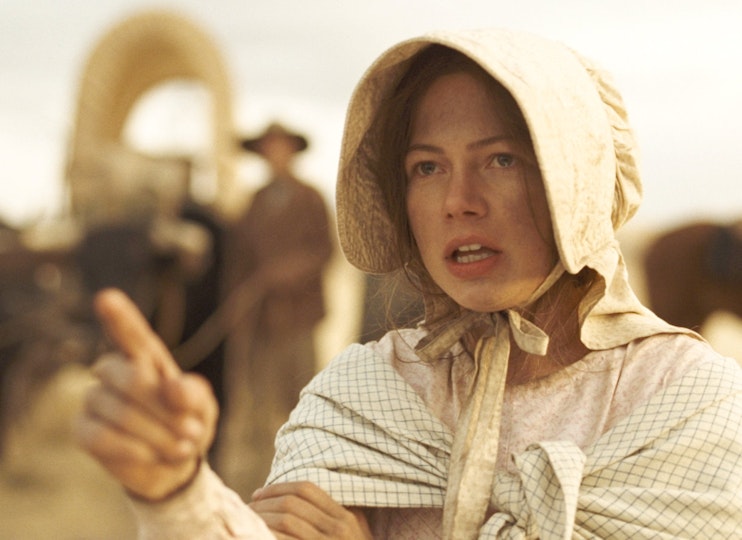 A person with light skin wearing a pale bonnet and shawl points at something with their right hand.