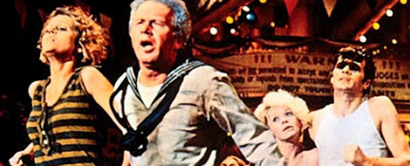 Four people with light skin are moving forward. The person in the middle has a sailor's suit on.