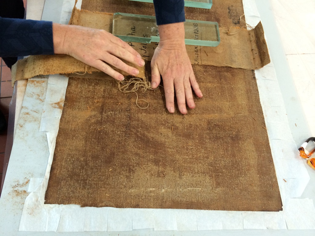 Peeling away the lining canvas during conservation