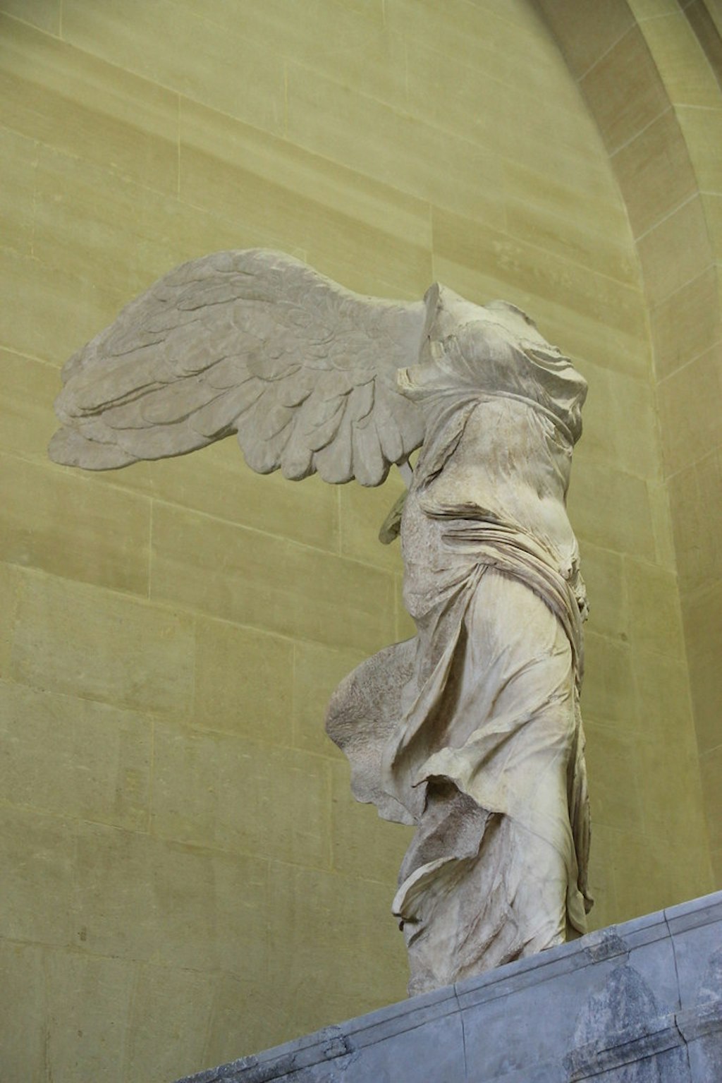 A marble statue of a headless figure with wings.
