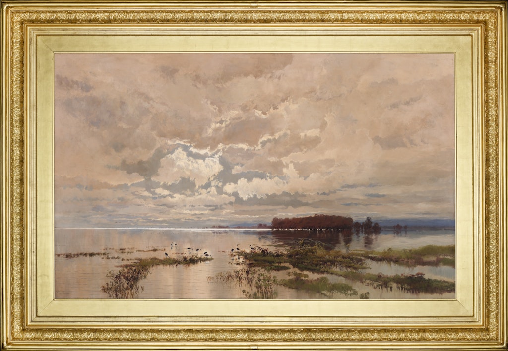 A gold-framed painting of a flooded plain with plants peaking through the water and sunlight shining through a cloud-filled sky.