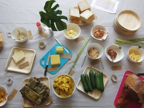 A selection of bowls containing ingredients that can be made into sandwiches, butter, cucumber, white bread, ham, corn chips, dips, chilli fermented vegetables